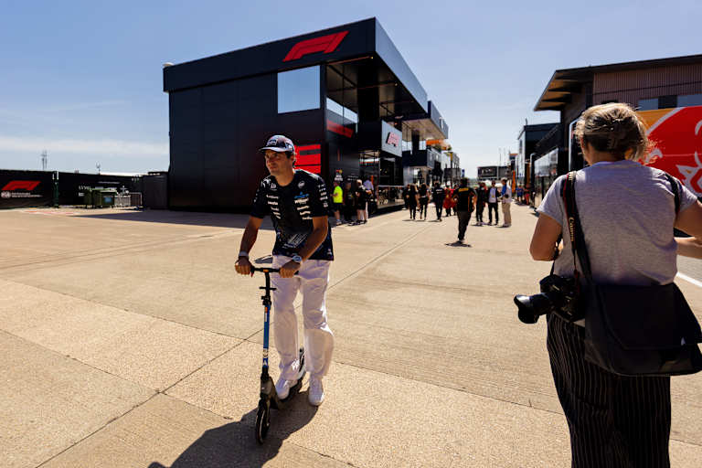 Carlos Sainz saust auf einem Roller durchs Paddock in Silverstone