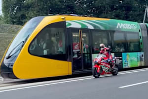 Takaaki Nakagami auf der MotoGP-Honda neben dem LRT-Zug