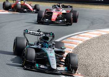 George Russell vor den Ferrari von Leclerc und Hamilton