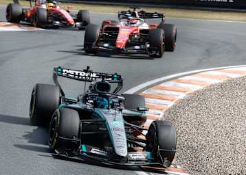 George Russell vor den Ferrari von Leclerc und Hamilton
