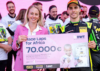 Anna Grubeck überreicht DTM-Champion Thomas Preining den symbolischen Check