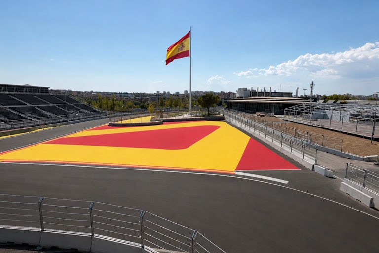 Hartes Anbremsen zu Kurve 1, hinten die grösste Nationalflagge von Spanien