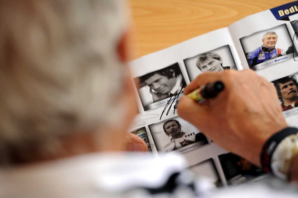 Giacomo Agostini signiert eine Motorrad-Rennsport-Publikation 