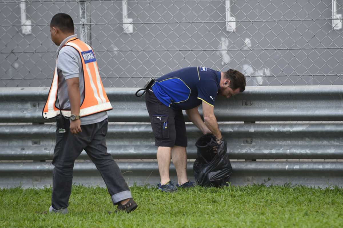 Ein Michelin-Techniker sammelt Gummistückchen zusammen und verstaut sie in einem Müllsack