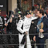 Die Schauspieler Brad Pitt (im weißen Rennanzug) und Javier Bardem auf dem Podium in Abu Dhabi. Links im Bild: Mercedes-Pilot George Russell