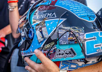 Mit einem Helm für den verstorbenen Teamchef unterwegs