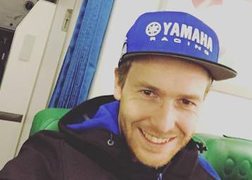 Danny de Boer mit Yamaha Kappe auf grünem Stuhl