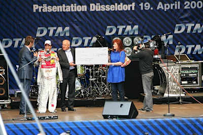 Timo Scheider und Astrid Elbers bei der Scheckübergabe