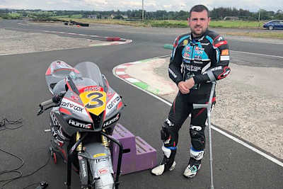 Michael Dunlop benötigt Hilfe, um auf sein Motorrad zu kommen
