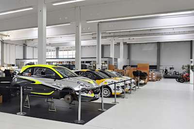 Hier sind die Rallyefahrzeuge Opel Adam zu sehen. Im Hintergrund die Kalex-Räumlichkeiten und ein paar Zweiräder