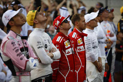 Die Fahrer lauschen der Hymne