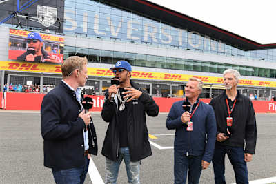 Lewis Hamilton mit Damon Hill (ganz rechts) und Johnny Herbert (Zweiter von rechts), links Craig Slater von Sky