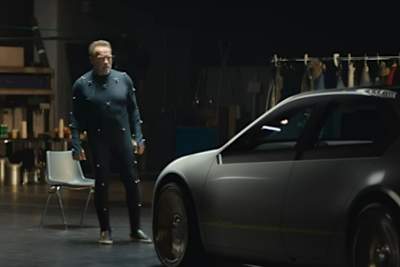 Arnold Schwarzenegger beäugt skeptisch die automobile Zukunft in Form des BMW i Vision Dee