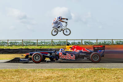 Kriss Kyle hüpft über den Red Bull Racing-Rennwagen mit David Coulthard am Lenkrad