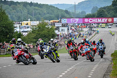 Adam McLean (56) biegt vor Gary Johnson (7) als Führender in die erste Kurve ein