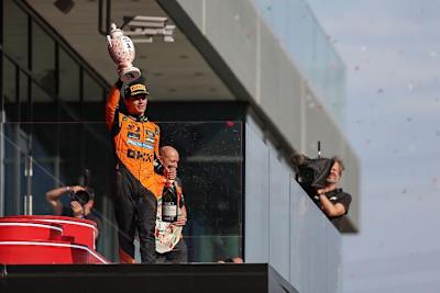 Lando Norris mit seinem Siegerpokal. Bevor mit Champagner gesprüht wurde, brachte er die zerbrechliche Trophäe zur Seite