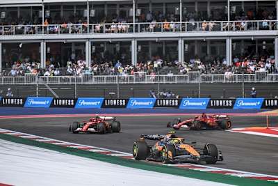 Lando Norris vor den beiden Ferrari