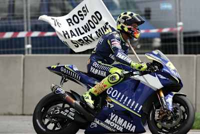 Valentino Rossi mit der selbstgemachten Flagge, mit der er sich bei Mike Hailwood entschuldigte