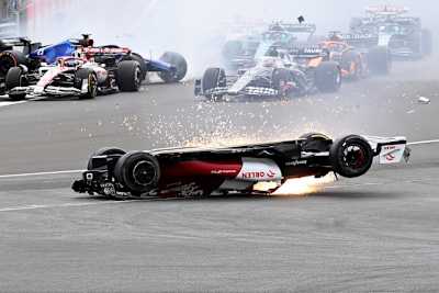 Guanyu Zhou im umgestürzten Alfa Romeo, in den sprühenden Funken ist der Kopfschutz Halo gut zu erkennen