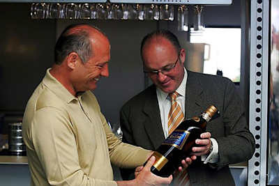 Ron Dennis erhält von Paul Walsh einen guten Tropfen