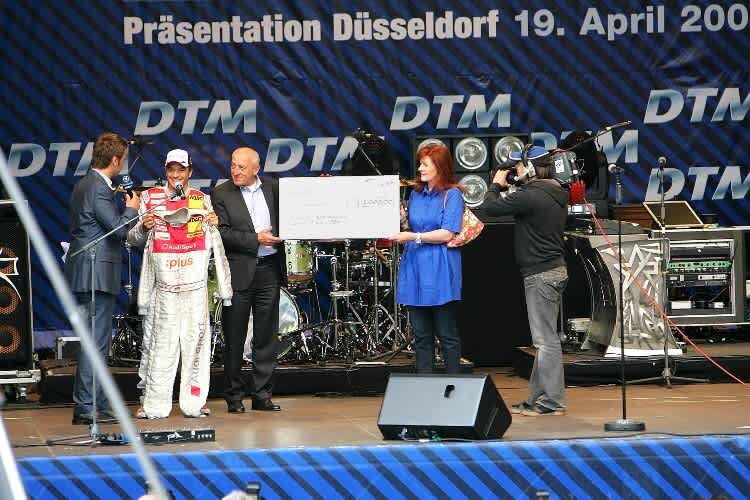 Timo Scheider und Astrid Elbers bei der Scheckübergabe