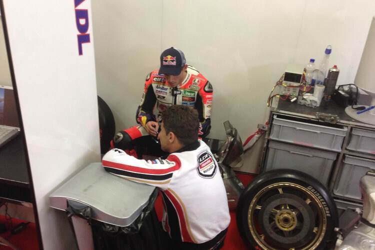 Stefan Bradl nach dem Rennen in einem Winkel der Box, vorne Lucio Cecchinello