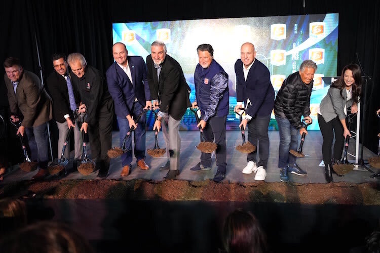 Spatenstich für das neue Rennwagenwerk, mit Rennlegende Mario Andretti (Zweiter von rechts), Michael Andretti (Fünfter von rechts) und Indiana-Gouverneur Eric Holcomb (links neben Michael)