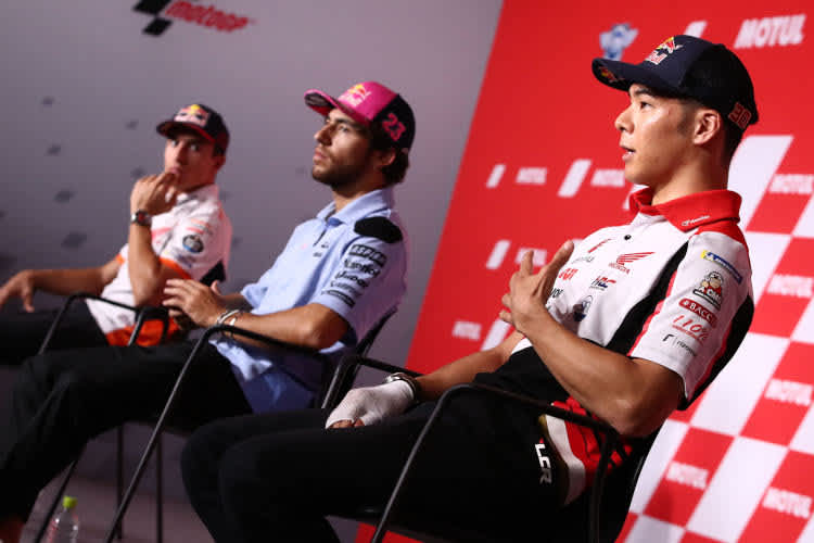 Taka Nakagami mit bandagierter Hand, im Hintergrund Bastianini und Márquez