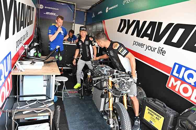 Domi Aegerter in der MotoE-Box in Assenb; links ten-Kate-Teammanager und Besucher Kervin Bos