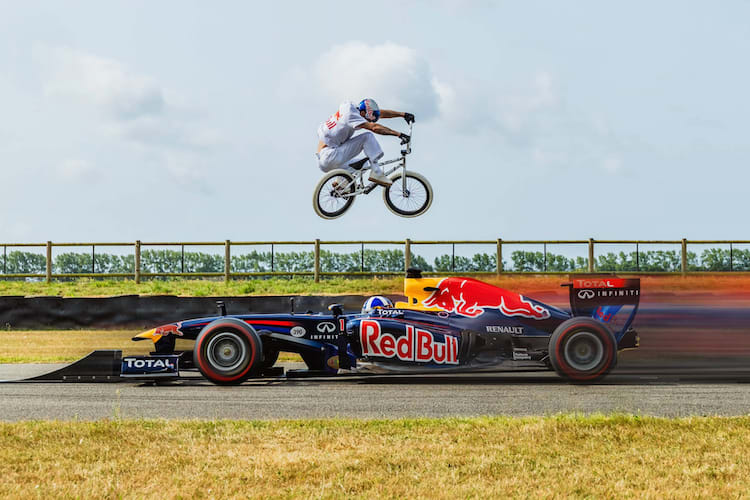 Kriss Kyle hüpft über den Red Bull Racing-Rennwagen mit David Coulthard am Lenkrad