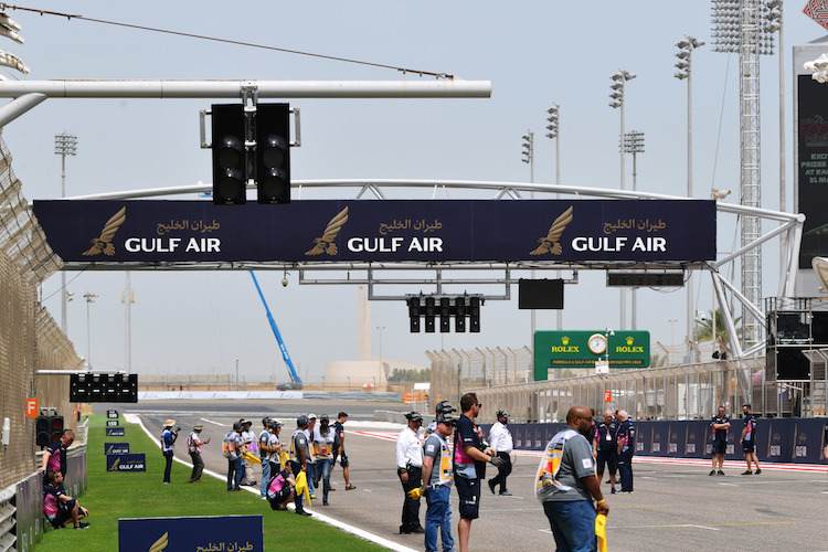 So sieht das in Bahrain aus: Normale Startampel (unter dem mittleren "Gulf Air"), Zusatzampel bei der fünften Startreihe (links oben am Querbalken), die niedrigen Leuchten unten links wegen des Halos (beim weissen F auf rotem Grund)