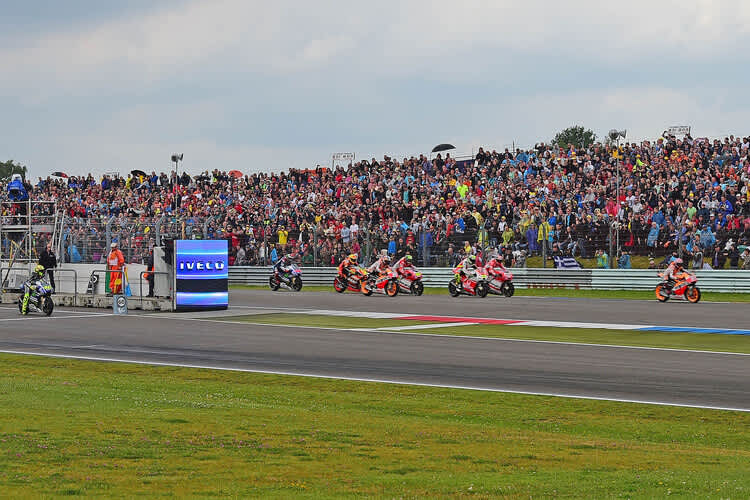 Start: Das Feld prescht davon, Rossi startet aus der Boxengasse