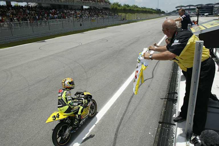 2004: Andrea Dovizioso kürt sich zum 125er-Weltmeister, Papa Antonio jubelt ihm zu