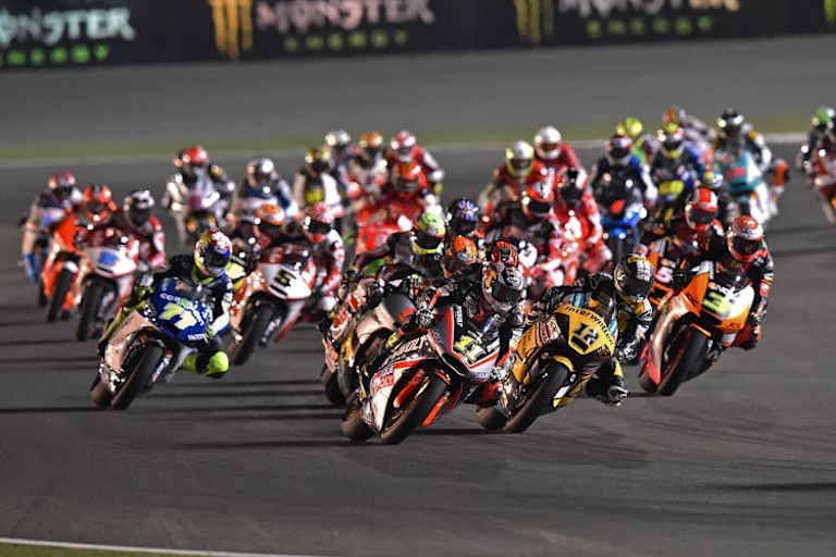 Nach dem Start biegt Sandro Cortese (11) vor Tom Lüthi (12) in die zweite Kurve