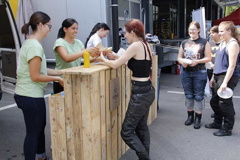 Die trotz enormer Hitze immer strahlende Linda Lustenberger hilft auch bei der Essensausgabe 