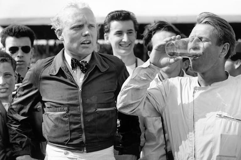 Mike Hawthorn (mit der unvermeidlichen Fliege) und sein Kumpel Peter Collins (am Trinken)