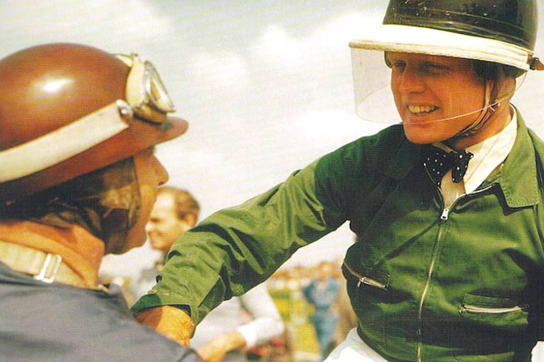 Mike Hawthorn in seiner typischen Rennmontur, mit Fliege und Windjacke, links Juan Manuel Fangio