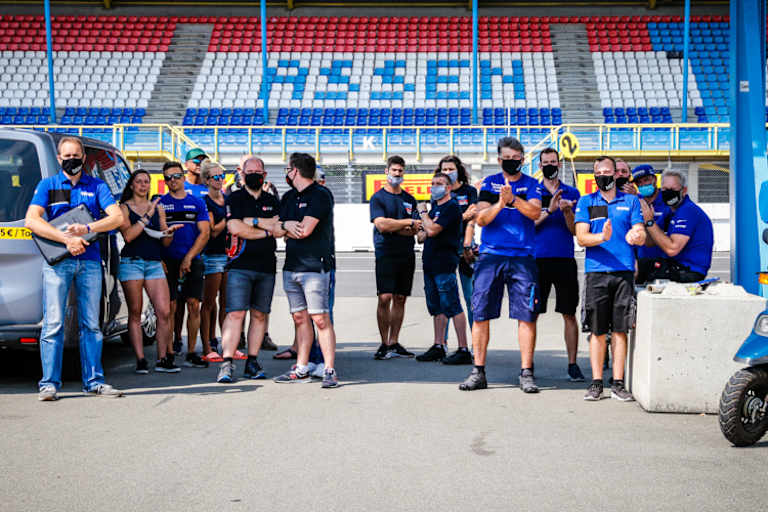 Das Team feiert mit Corona-Abstand