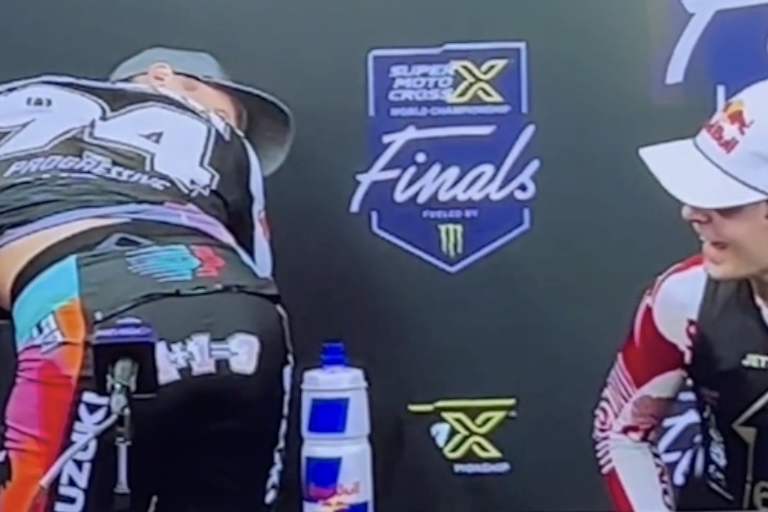 Ken Roczen zeigt Jett Lawrence während der Pressekonferenz das Butt Patch mit der Aufschrift 1+1=3