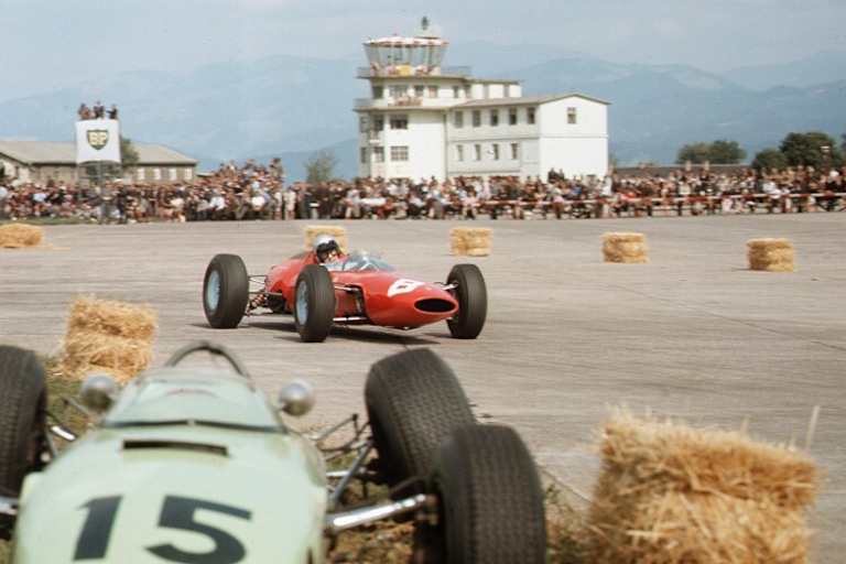 Lorenzo Bandini in Zeltweg 1964. Im Vordergrund der wegen Aufhängungsschaden gestrandete BRM von Trevor Taylor