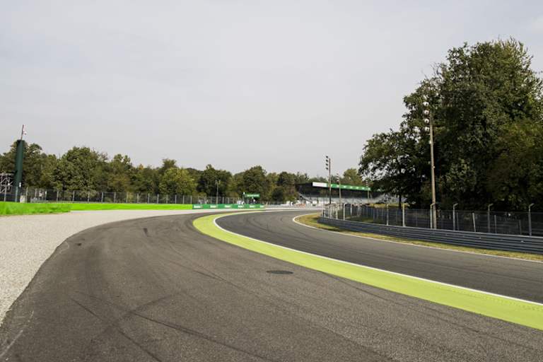 Die Parabolica: Ganz rechts die eigentliche Bahn, dann der Grünstreifen, asphaltierte Auslaufzone, erst dann das Kiesbett und die Reifenstapel