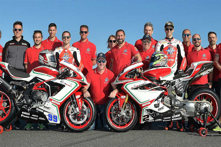 Teamchef Andrea Quadranti kniend auf dem Boden in der Mitte