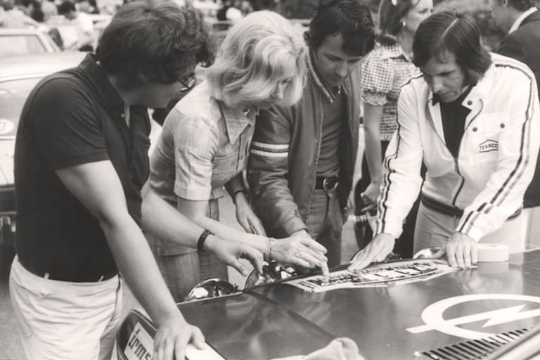Der Weltmeister klebt Startnummern, von links: Reinke, Dencker-Anderson, Braun, Fittipaldi, im Hintergrund Maria Helena Fittipaldi und François Mazet